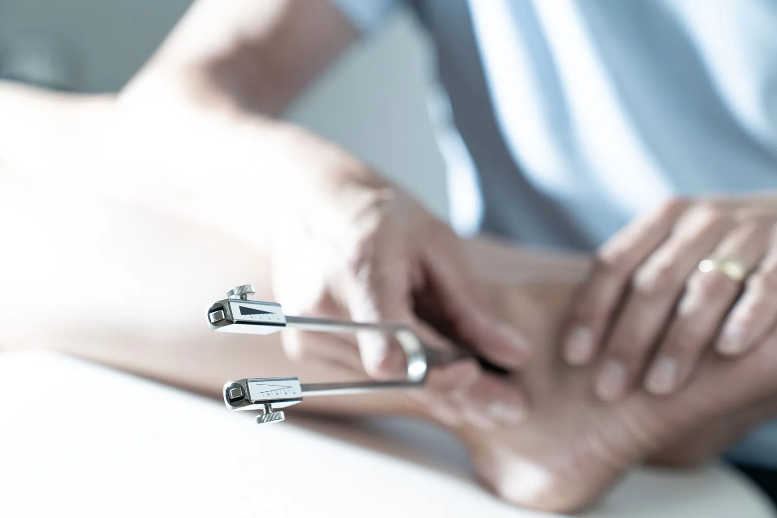 Prüfung des Vibrationsempfindens mit der Stimmgabel am Fuß